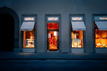 Exterior of a Hermès boutique showcasing luxury handbags, including the iconic Birkin collection. 