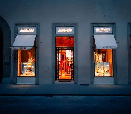Exterior of a Hermès boutique showcasing luxury handbags, including the iconic Birkin collection. 